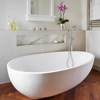 white bathroom with bathtub and wooden floor