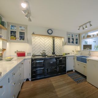 kitchen with white cabinet white counter white wall and wooden flooring