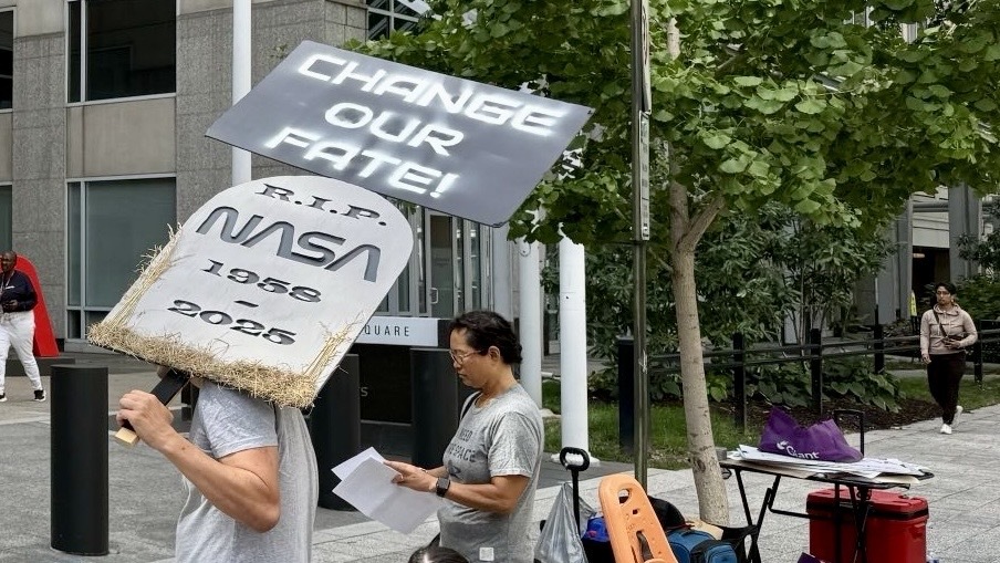 NASA抗議活動的一組圖像最近表明，許多人在玻璃門前拿著一個帶有紅色字體徽標的麥克風和NASA的總部。
