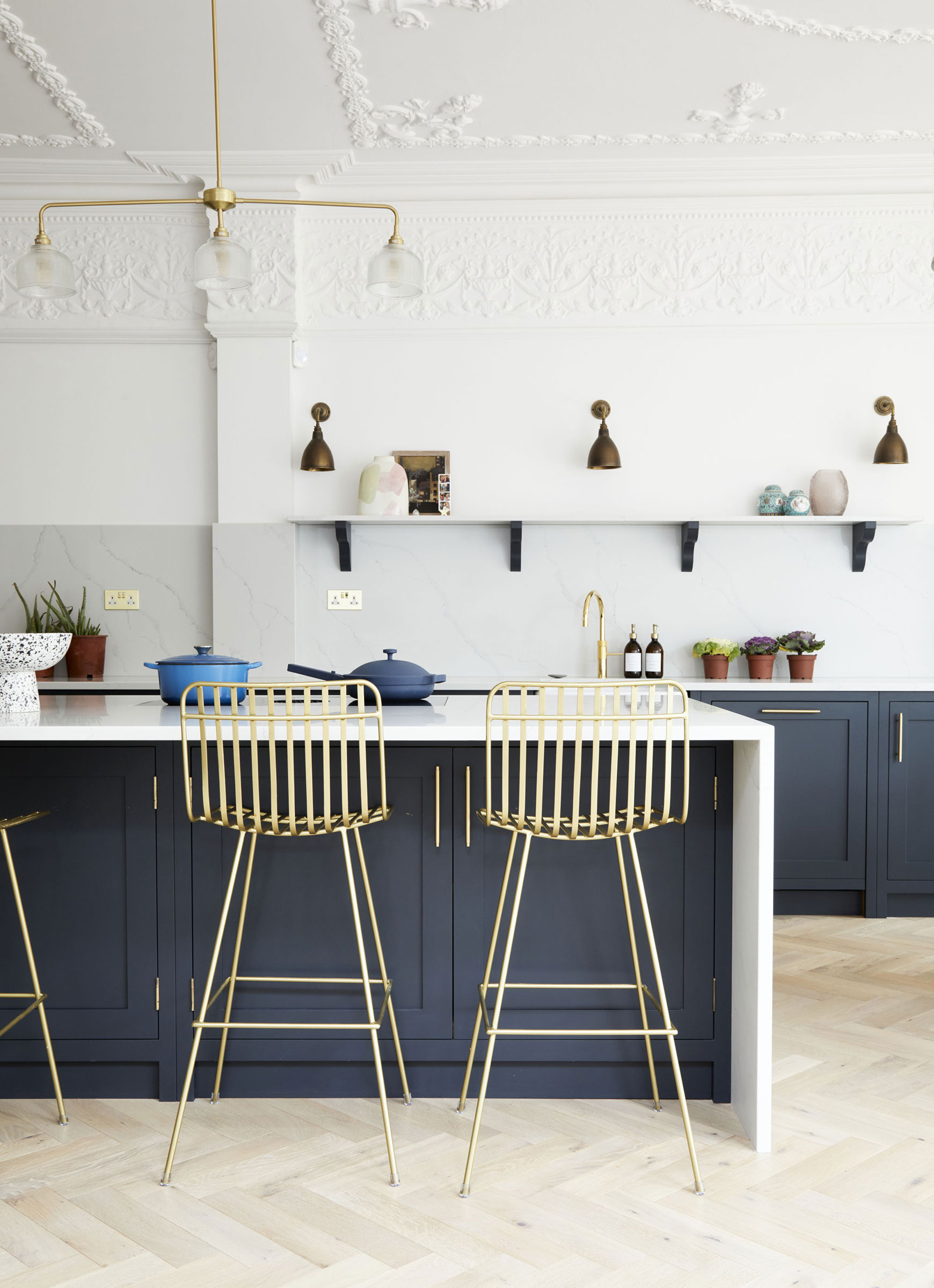 blue kitchen with white island and high ceiling with mouldings