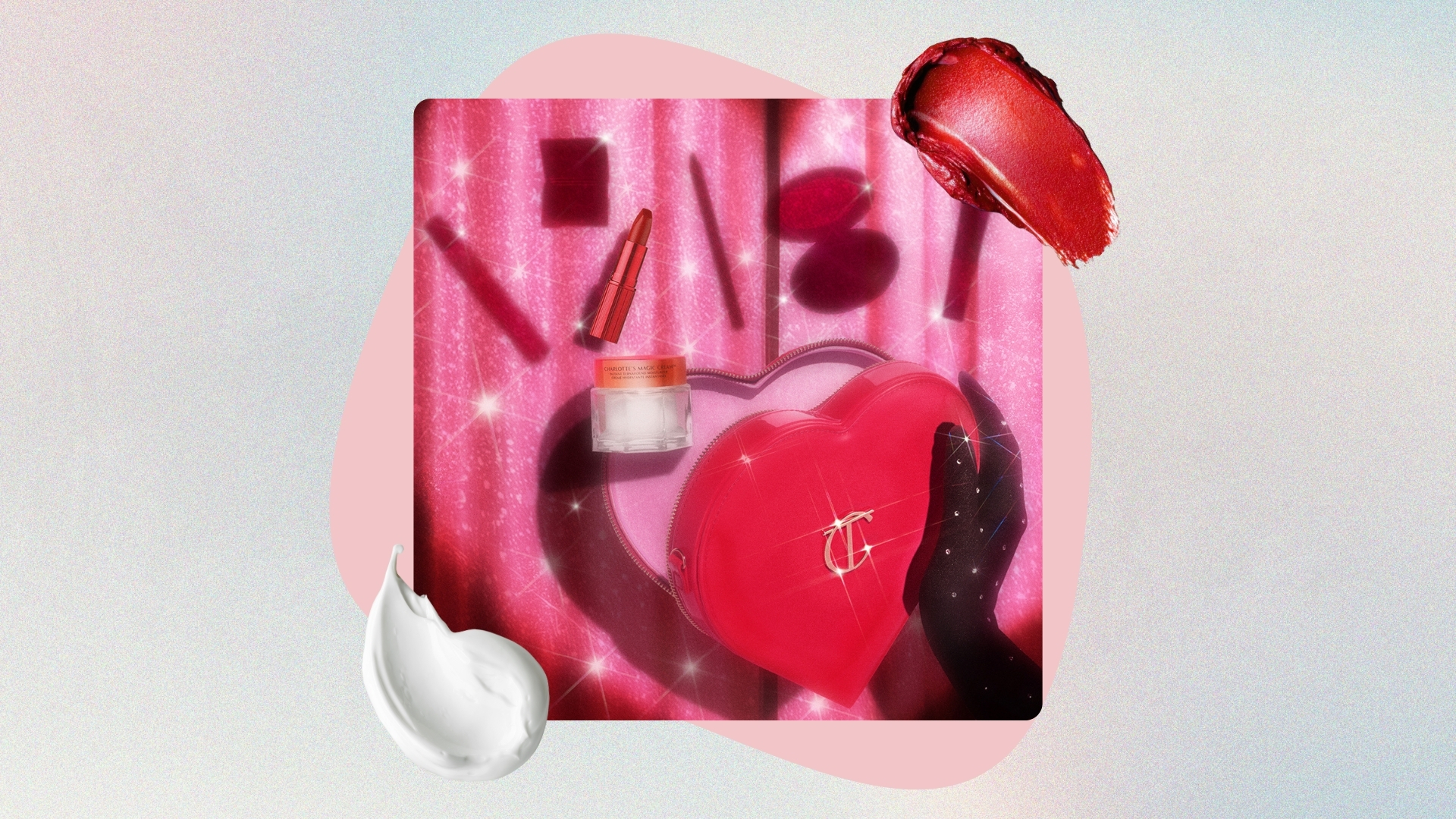 Image of hand holding Charlotte's Mystery L.O.V.E Look Bundle and its contents above, on a pastel watercolour background with pink circle, red lipstick swatch and white cream swatch