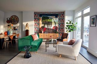 A living room with an emerald green sofa