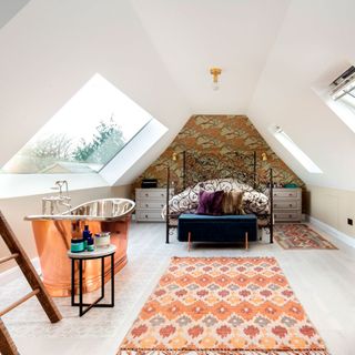 attic bedroom with metal bed and copper bathtub