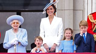 Queen Elizabeth II, Prince Louis of Cambridge, Catherine, Duchess of Cambridge and Princess Charlotte of Cambridge watch the RAF flypast