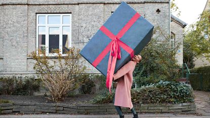 Smiling woman carrying very large present
