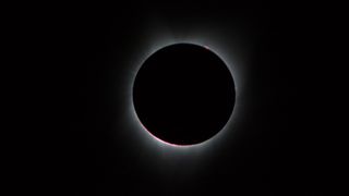 The sun's visible-light corona, the inner part of which is only visible during a total solar eclipse, is seen here as a pearly crown of light surrounding the darkened, Earth-facing side of the moon, as seen on Aug. 21, 2017. 