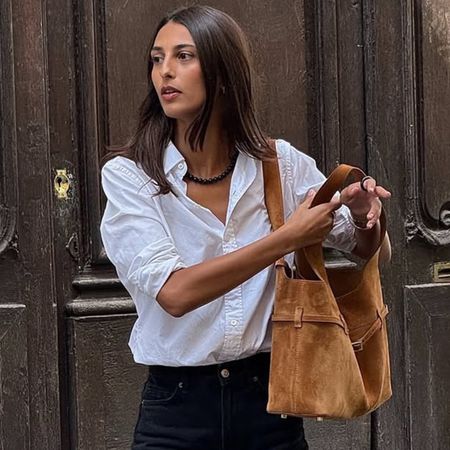 @salome.mory wearing a white button-down shirt with a cognac suede bag, French girl capsule wardrobe essentials.