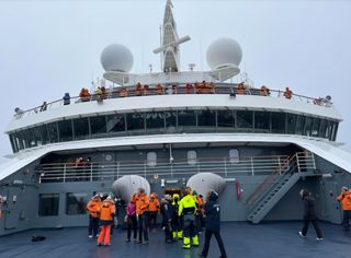 A view from the stern of Le Commandant Charcot looking up toward the ship's bridge under overcast skies prior to the start of the total solar eclipse of 2021.