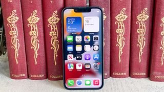 iphone 13 mini display on leaning against books