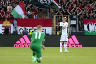 Hungary’s Bendeguz Bolla stands while Republic of Ireland midfielder James McClean takes a knee at the Szusza Ferenc Stadium in Budapest