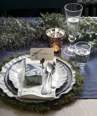 Rustic christmas place setting with green leaves centerpiece