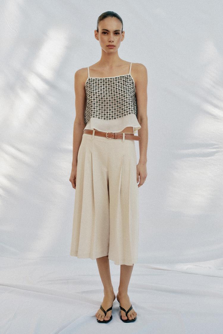 woman wears camisole with culotte trousers.