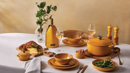 Yellow cast iron pot and dinnerware on table