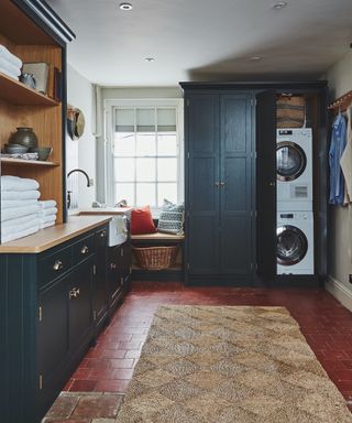 laundry room with seagrass rug and painted cabinetry