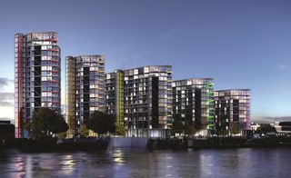 Nine Elms Riverlight nighttime view of five residential blocks next to each other next to river