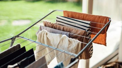 Drying laundry on drying rack by the window with sunlight