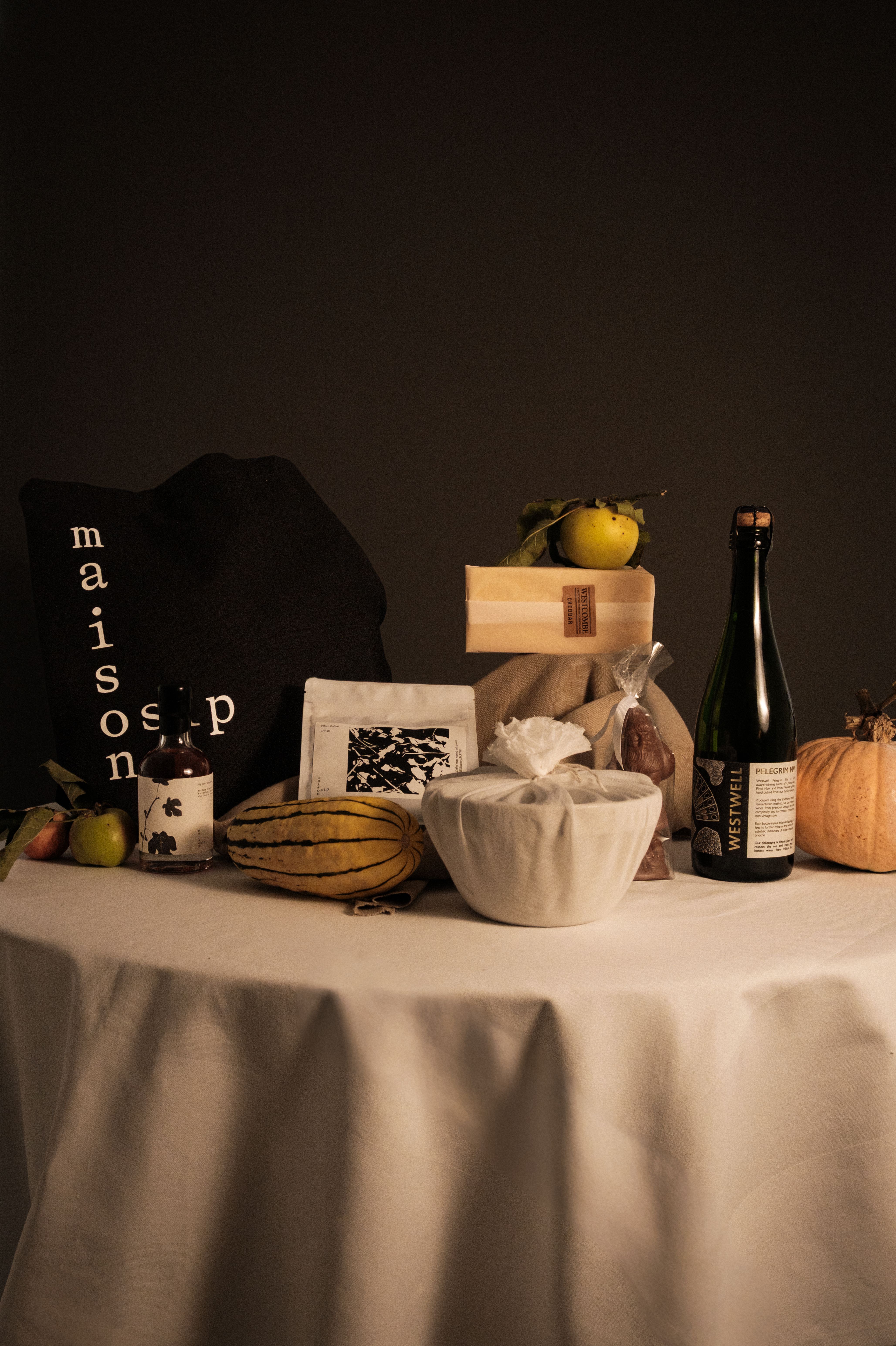 A series of shots depicting the interiors of a modernly renovated, old farmhouse in the countryside, mixing a rustic frame with plush textiles, textural surfaces, glass, wood, and chrome accents, and colorfully plated dishes.