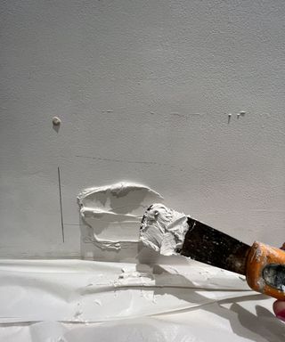 tile adhesive being applied to white wall