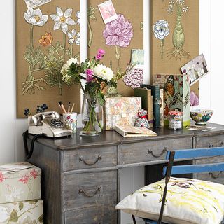 craft on white wall with books telephone and flower vase on wooden drawer storage cabinet