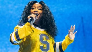 SZA performing live wearing a yellow top