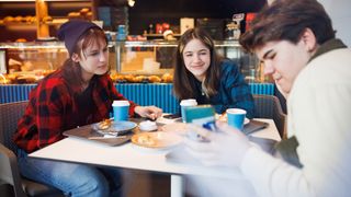 Teens using wifi in cafe