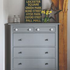 A chest of drawers with flowers and decor on top