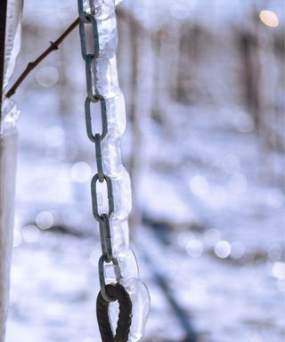 A frozen rain chain in a snowy environment