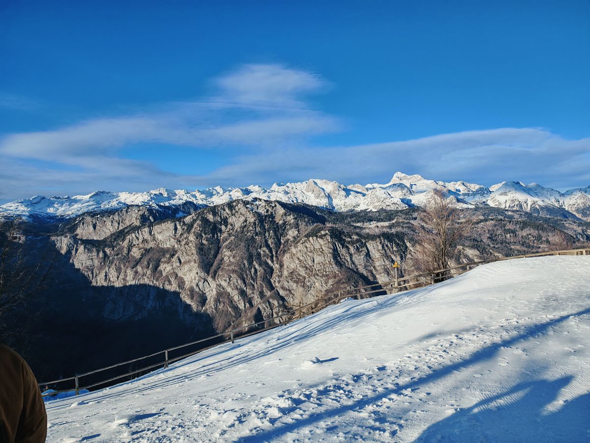 Hiking on a snowy trail with snow capped mountains in the distance