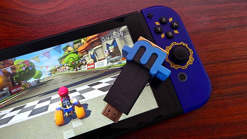 mClassic upscaler sitting on Nintendo Switch with Mario Kart on screen and Skyward Sword Joycon attached on woodgrain desk.