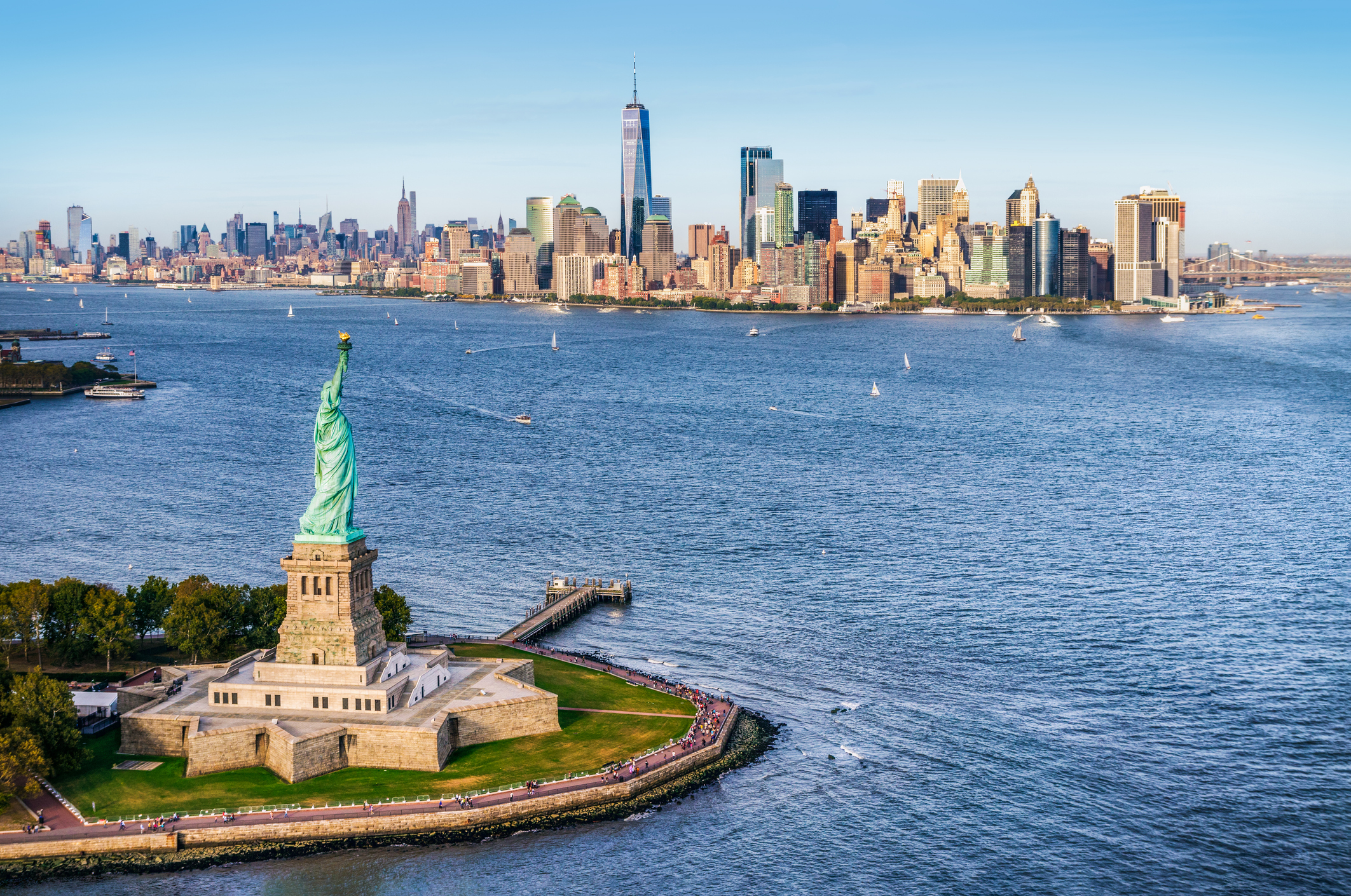 Aerial view of the statue of liberty in front of Manhattan, New York skyline.