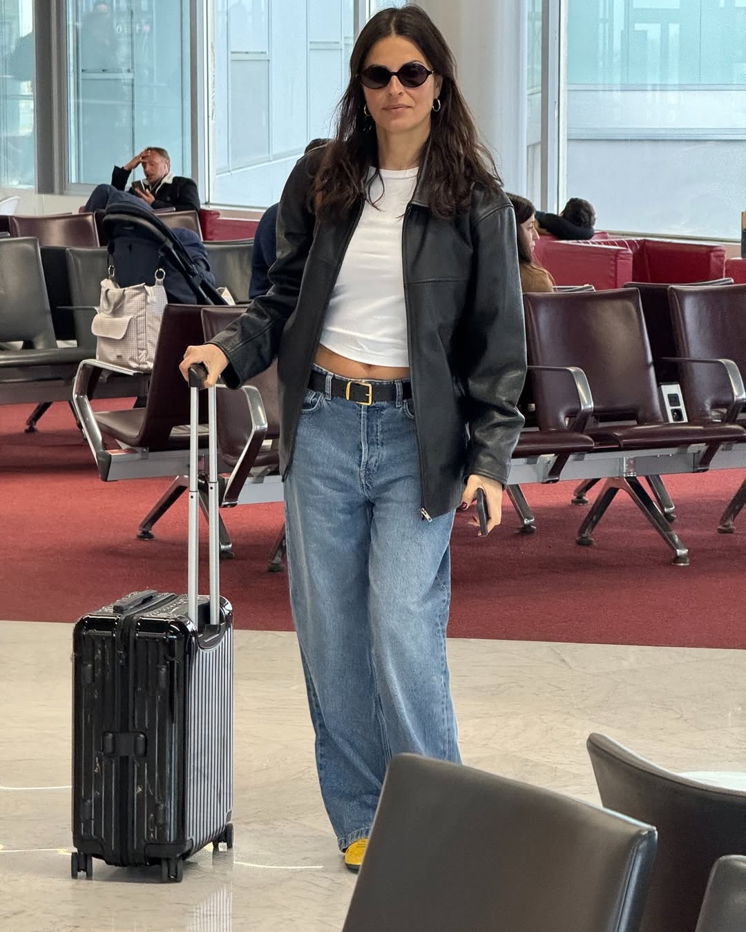 Elisabeth Bento wearing mid-rise wide leg jeans at the Paris airport.