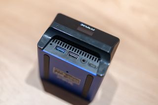 A blue and black Xulu XR1 Max mini PC on a wooden desk