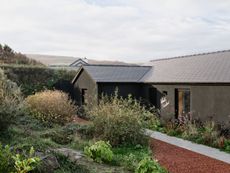 view of a welsh cottage or bungalow type building facing the sea and redesigned in a fairly minimalist, contemporary way