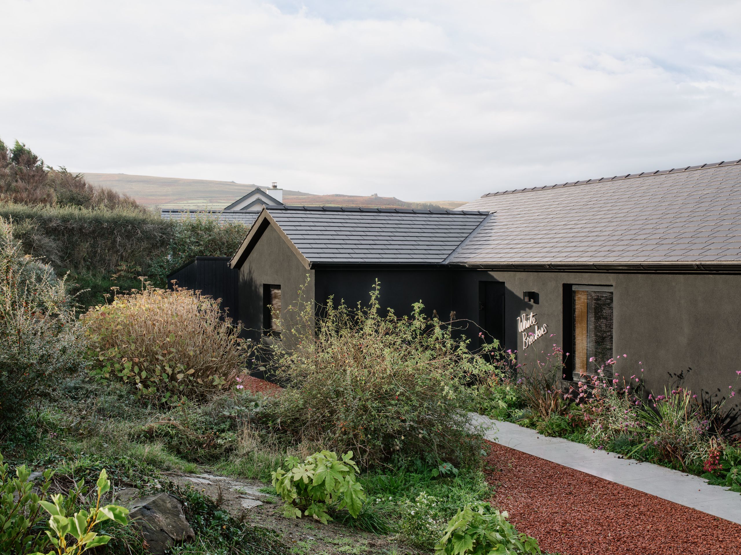 A dark and ‘stealthy’ Welsh cottage reimagines life by the Irish Sea