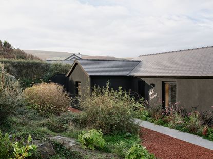view of a welsh cottage or bungalow type building facing the sea and redesigned in a fairly minimalist, contemporary way