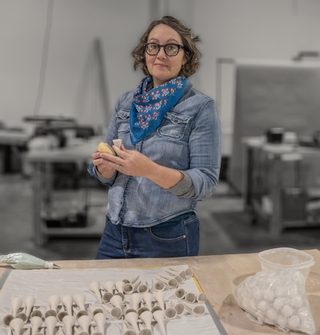 Jen Rose, owner of Bee Cups, and a table of bee cups being made