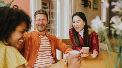 Friends hang out to talk and drink coffee at a café.