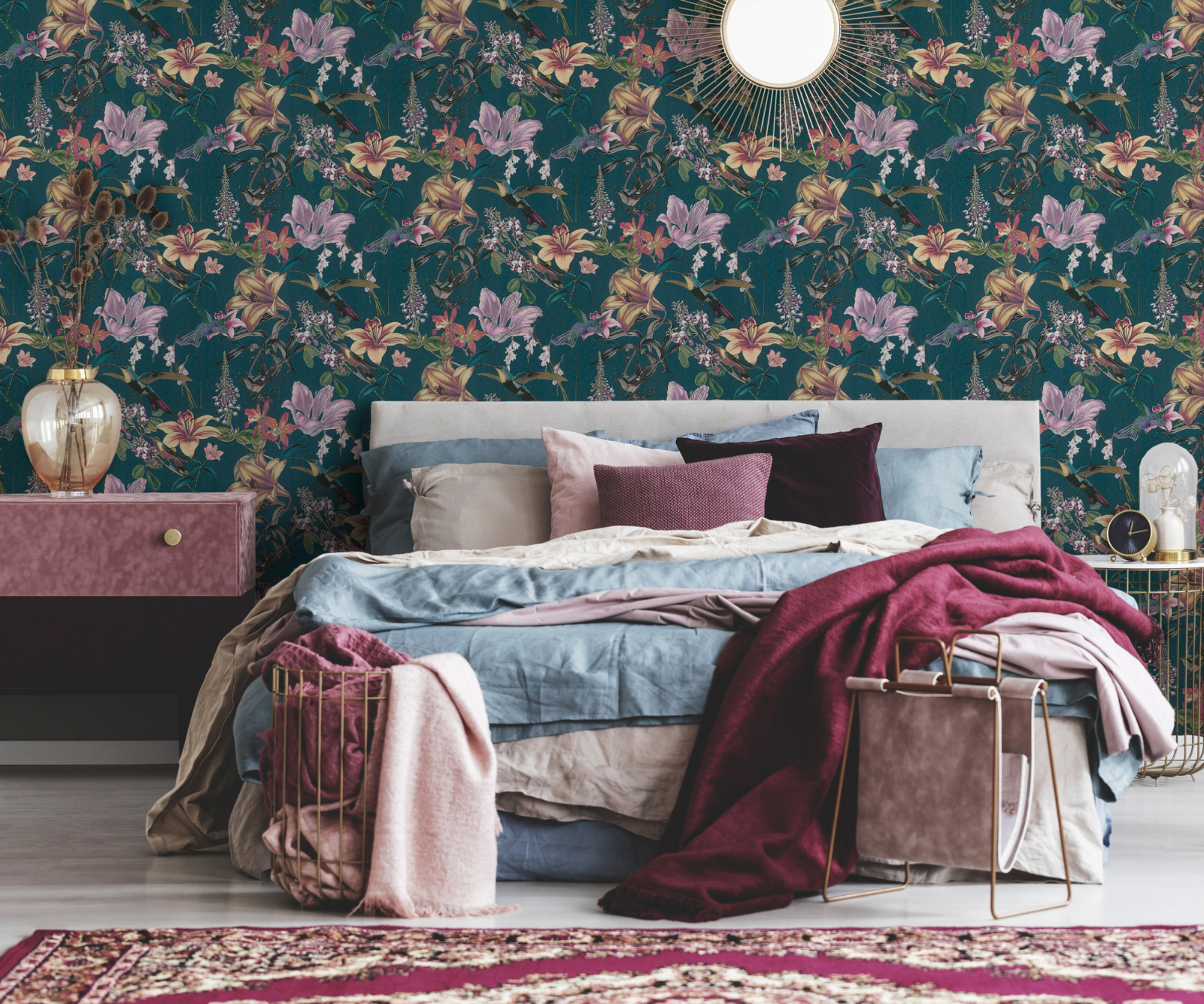 pink and blue botanical wallpaper behind bed with blue and pink bed linen and throws