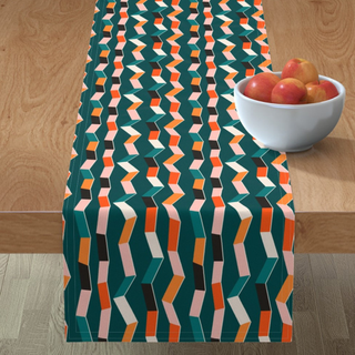 An emerald green table runner with bright zigzag pattern in geometric white, orange, and pink