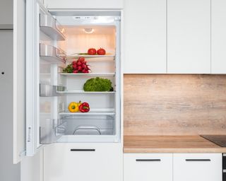 White fridge open with vegetables inside