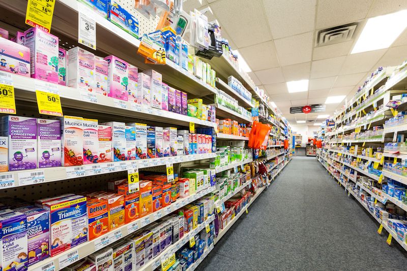 The shelves of a drug store are lined with medicines.