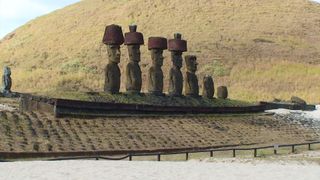 Statues at the base of a hillside on Easter Island.