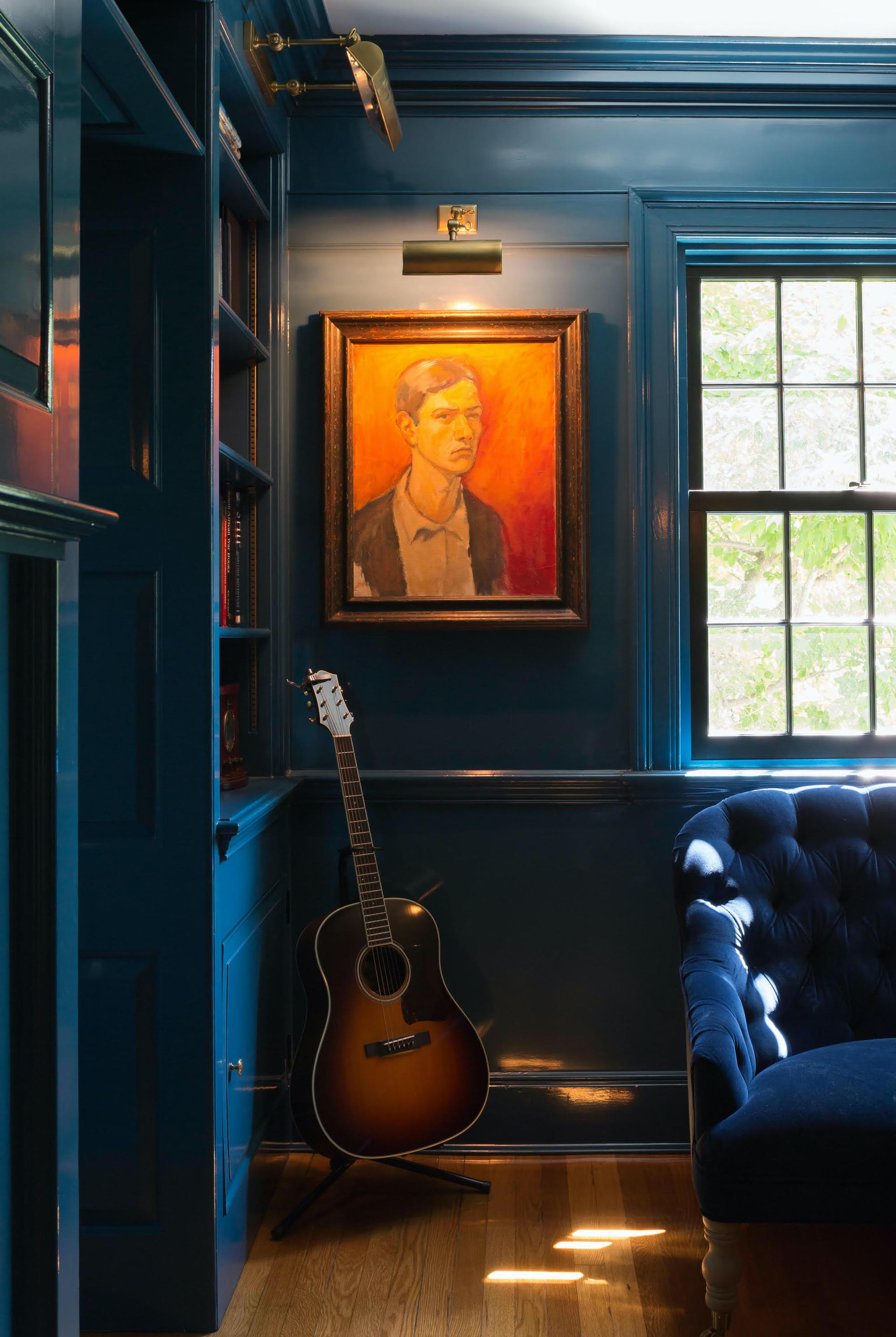 A room with wainscoting painted in a dark blue color, floor to ceiling