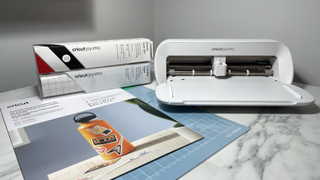 Cricut Joy Xtra review; a small white craft machine on a marble worktop with materials