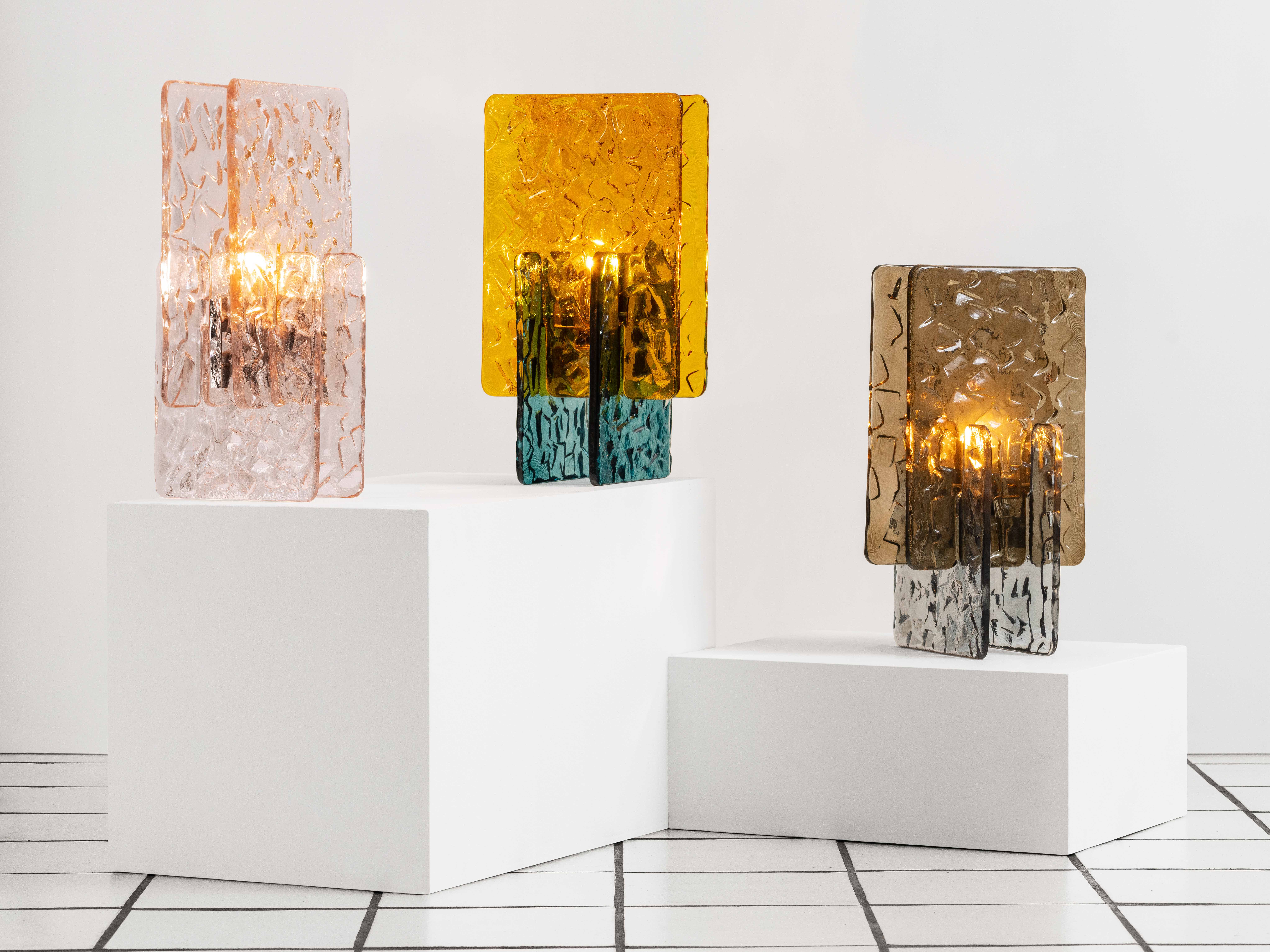 colourful glass lighting sculptures in white-tiled room