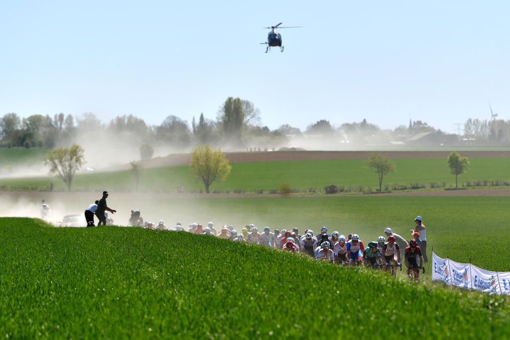 ROUBAIX FRANCE APRIL 17 A general view of the peloton compete passing through a dusty cobblestones sector landscape during the 119th ParisRoubaix 2022 Mens Elite a 2572km one day race from Compigne to Roubaix ParisRoubaix WorldTour on April 17 2022 in Roubaix France Photo by Luc ClaessenGetty Images