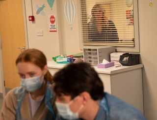 Charity Dingle looks at Chloe and Mack in the hospital through a window