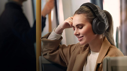 Jabra Elite 85h noise cancelling wireless headphones being worn by a woman on a subway train