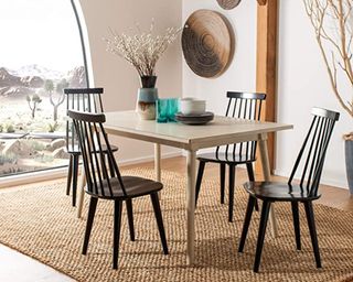 A wooden dining table with black spindle dining chairs in a modern dining room
