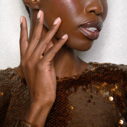 model backstage at fashion week with smooth hands and a pink manicure